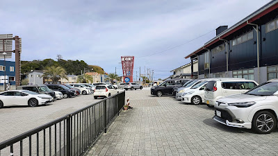道の駅前の駐車スペース。道の駅よつくら港のモニュメントが見えます。