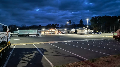 大型車エリアの様子。奥にトイレ棟とお土産・産直の建物が確認できます。乗用車エリアとは離れて停めることが可能です。