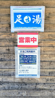 足湯の外観と案内板。山の景色を眺めながら入れます。