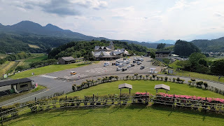 展望台から見た建物正面の駐車場。山に囲まれた盆地の立地がよくわかります。