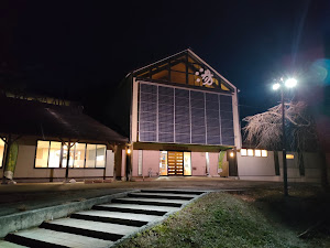 夜の水沢温泉館外観。「湯」の文字と太陽光パネルが目を引きます。