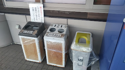 自動販売機横のリサイクルボックス。「燃えるゴミの回収はしておりません」の看板あり