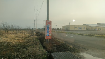 臨時駐車場は7号線からの右折入場ができないので、一度信号を右折したあとに、この看板の手前の道を左折します。（左折後の道は狭いので注意）