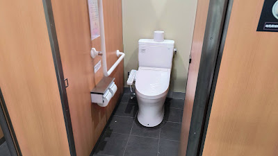 個室内はウォシュレット付き。木目調の扉で清潔感あり。