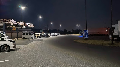 夜間の駐車場。照明はあるが、場所によって明るさにムラがあります。