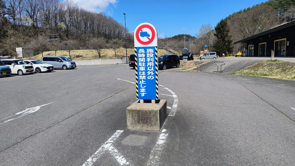 アトリエ棟駐車場入口にある看板。「施設利用以外の長時間駐車は禁止します」