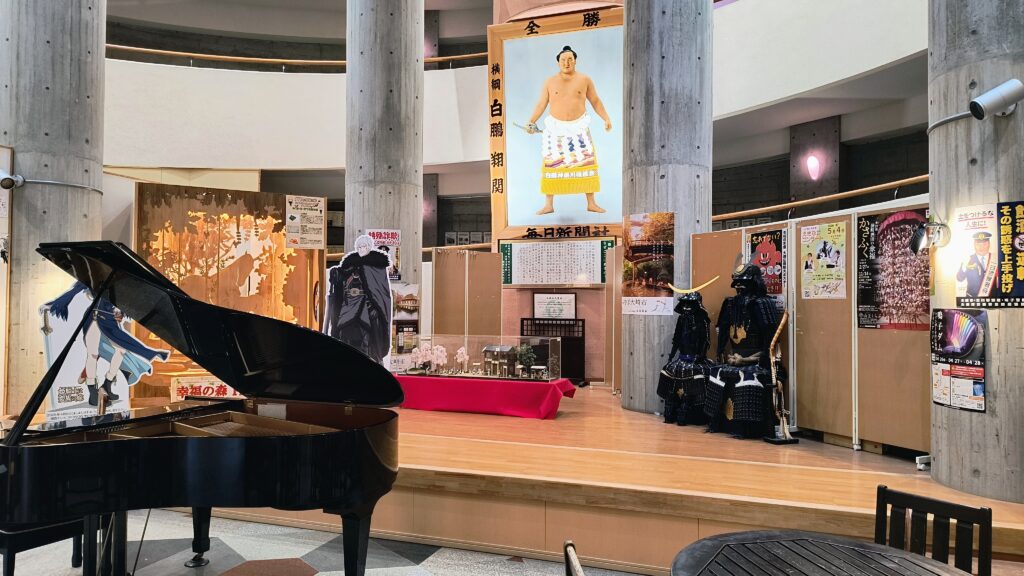 建物中央の展示コーナー。白鵬の優勝記念パネルや伊達政宗公の鎧、ストリートピアノなどが展示されています。