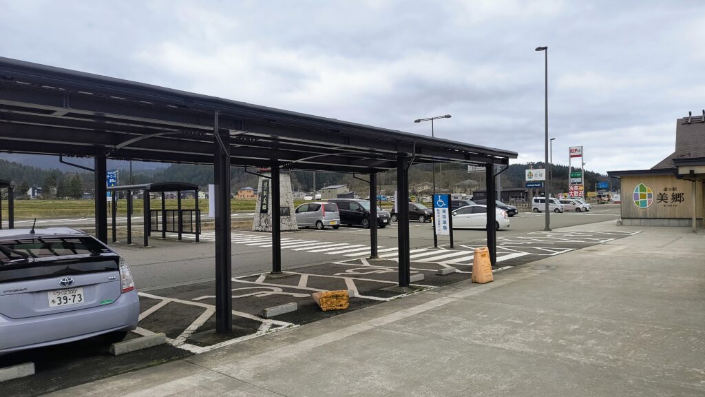 ​道の駅美郷の駐車場。店舗前には屋根付きの優先駐車場（車いす使用者用駐車区画）が完備されています。