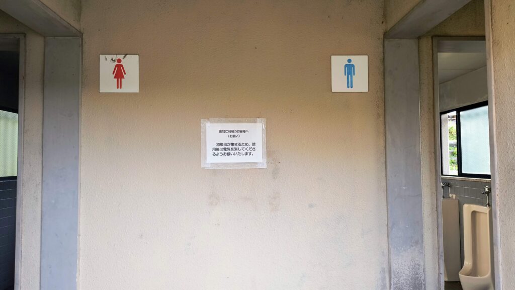 トイレ入り口には「羽虫が出るため夜間は使用後に電気を消してください」の表示。