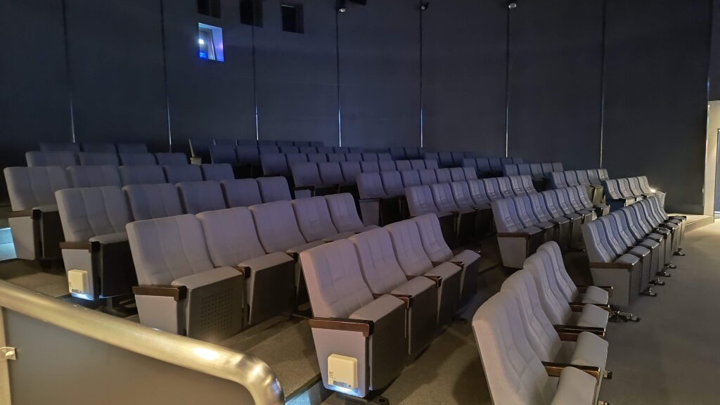 ふるさとシアターの座席。訪問時は新潟のローカルCMが上映されていました。(会場直後だったので他のお客さんは誰もいません)